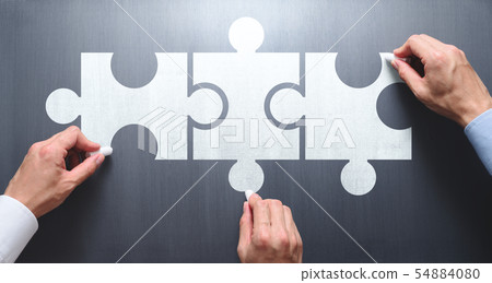 協同工作以尋找解決方案並使業務成功的圖像。三個人在黑板上畫一個連接的拼圖塊 54884080