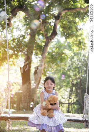 Joyful happy cute girl hugging teddy bear sitting Joyful happy cute girl hugging teddy bear sitting 54885160