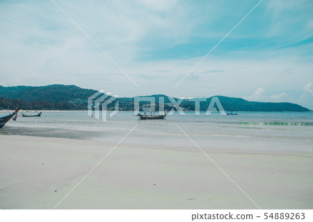 sandy beach and tropical greenery of the island. tourists and boats by the sea sandy beach and tropical greenery of the island. tourists and boats by the sea 54889263