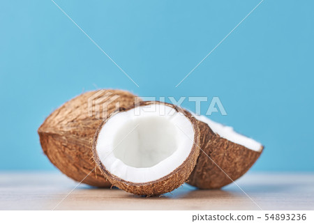 Full Coconut and cracked half on a blue background Full Coconut and cracked half on a blue background 54893236