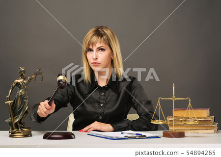 A young fair woman judge works in her office. A young fair woman judge works in her office. 54894265