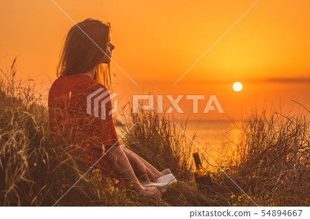Young blonde girl in red dress sitting 54894667
