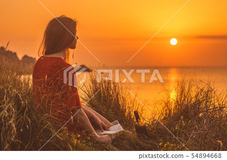 Young blonde girl in red dress sitting 54894668