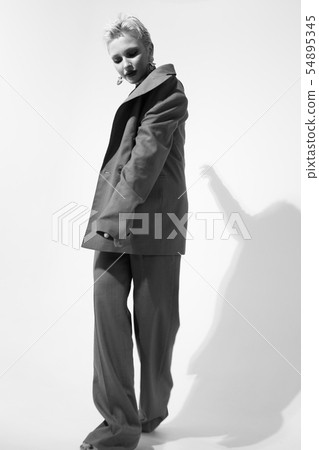Stylish young woman in a suit in the studio on a white background. Short haircut. Black and white 54895345