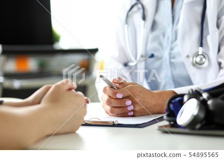 GP in clinic receiving sick visitor discussing health complaints 54895565