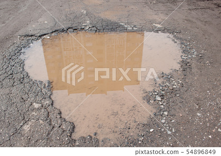 Big pothole filled with water. 54896849