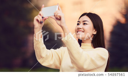 Young girl making photo of city on phone 54897561