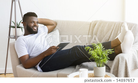 Young millennial guy using digital tablet at home 54897657