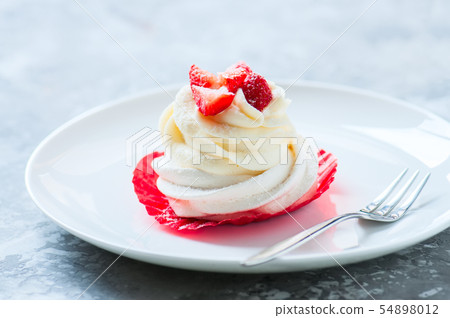 One beautiful pavlova dessert in a plate. 54898012