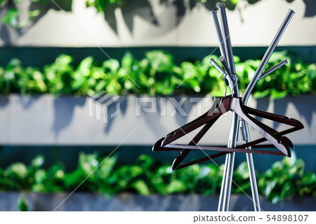 Metallic stand with empty Hanger for clothes in cafe interior Metallic stand with empty Hanger for clothes in cafe interior 54898107