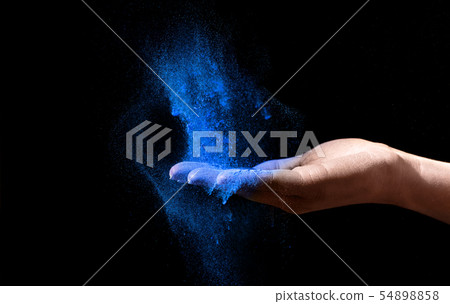 Woman Hand holding blue holi powder over black background Woman Hand holding blue holi powder over black background 54898858