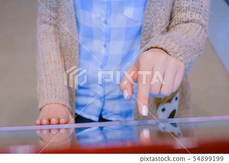 Woman using multimedia touchscreen display of interactive kiosk Woman using multimedia touchscreen display of interactive kiosk 54899199