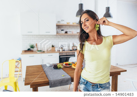 Beautiful playful woman show earrings from grape 54901483