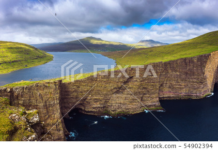 Huge cliff and lake Sorvagsvatn on island of Vagar, Faroe Islands, Denmark. 54902394