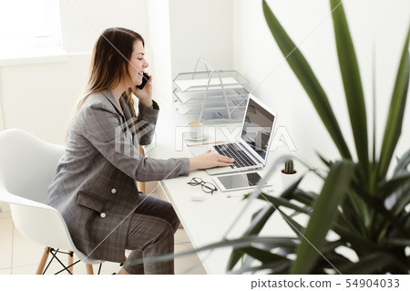 younger girl working in the office at the table 54904033