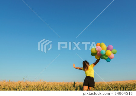 young woman with balloons on summer field young woman with balloons on summer field 54904515