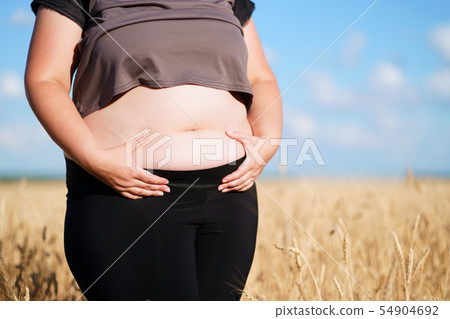 Fat woman in sportswear standing in wheat field 54904692