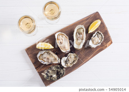 Fresh Oysters with lemon and white wine 54905014
