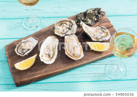 Fresh Oysters with lemon and white wine 54905016