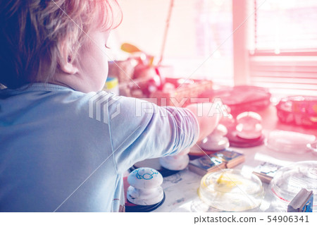boy is having fun while playing with stamps and boy is having fun while playing with stamps and 54906341
