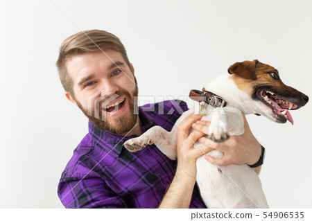 Pet's owner concept - young man playing with puppie on white background 54906535
