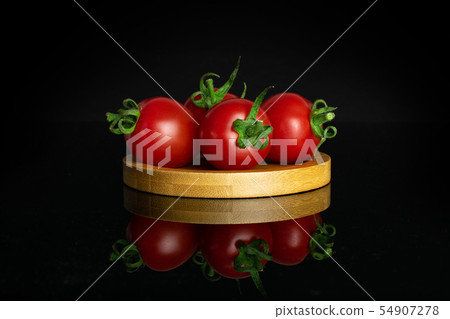 Red cherry tomato isolated on black glass Red cherry tomato isolated on black glass 54907278