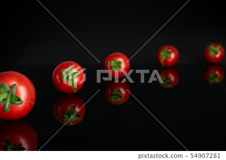 Red cherry tomato isolated on black glass Red cherry tomato isolated on black glass 54907281