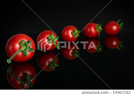 Red cherry tomato isolated on black glass Red cherry tomato isolated on black glass 54907282
