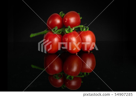 Red cherry tomato isolated on black glass Red cherry tomato isolated on black glass 54907285