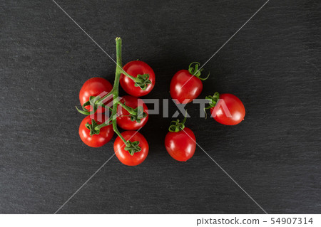 Red cherry tomato on grey stone Red cherry tomato on grey stone 54907314