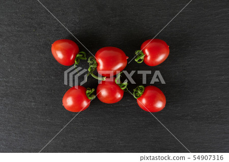 Red cherry tomato on grey stone Red cherry tomato on grey stone 54907316