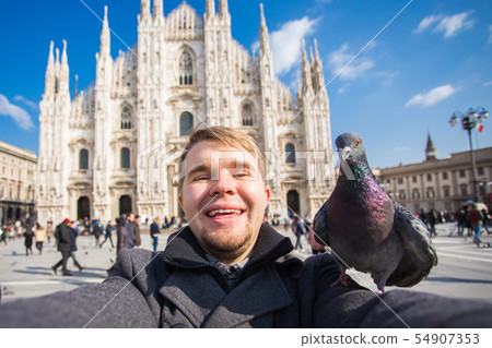Travel, holidays and winter vacations concept - Happy man take selfie photo with funny pigeons in 54907353