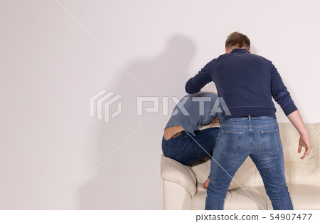 alcoholic, domestic violence and abuse concept - man gets drunk at home and takes his anger at his 54907477
