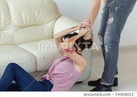domestic violence, victim and abuse concept - cruel aggressive man grabbing woman lying on the floor domestic violence, victim and abuse concept - cruel aggressive man grabbing woman lying on the floor 54908052