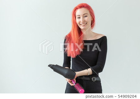 Hairdresser, style, people concept - woman is blowing dry her colored hair Hairdresser, style, people concept - woman is blowing dry her colored hair 54909204