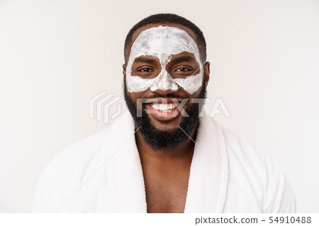 Young african-american guy applying face cream on white background. Portrait of a young happy 54910488