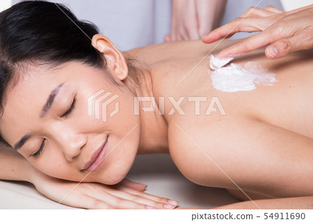 Professional Therapist scrub with light gentle red beat herbal Beauty Treatment on Asian woman skin back in the Health Spa, for smooth clean refresh new skin by scrubbing old one out 54911690