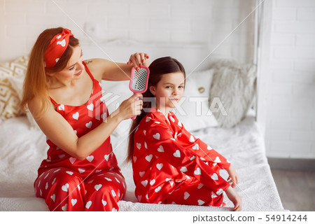 Cute mother and daughter at home in a pajamas Cute mother and daughter at home in a pajamas 54914244
