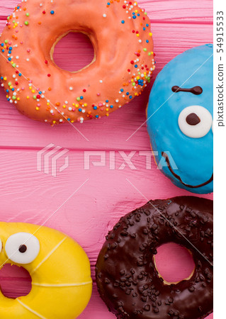 Donuts frame on pink wooden background. Donuts frame on pink wooden background. 54915533