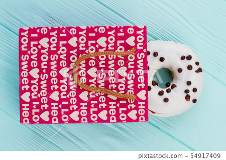 White donut in pink shopping bag. 54917409