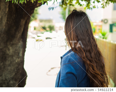 Young woman outdoors turned with her back 54922214