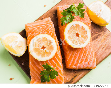 Salmon fillet on wooden board with lemon slices 54922235
