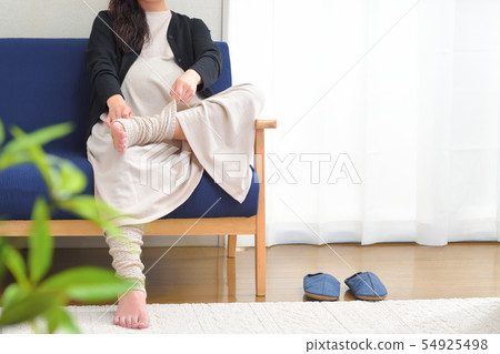 A pregnant woman who warms his legs with leg warmers 54925498