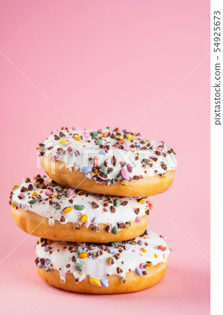 Donuts with icing on pastel pink background. Sweet donuts. Copy space. 54925673