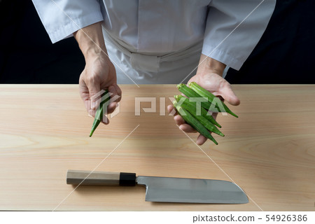 Board front holding okra in hand 54926386