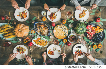Friends eating at Thanksgiving Day table with 54927353