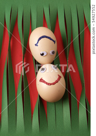 Eggs with eyes isolated on striped green paper Eggs with eyes isolated on striped green paper 54927552