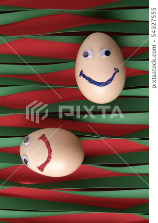 Eggs with eyes isolated on striped green paper Eggs with eyes isolated on striped green paper 54927555