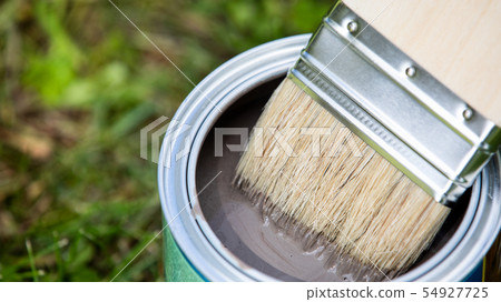 Open can of brown paint with brush 54927725