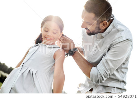 The best father ever. Kind young father adjusting hair clips for his cute daughter while spending 54928071